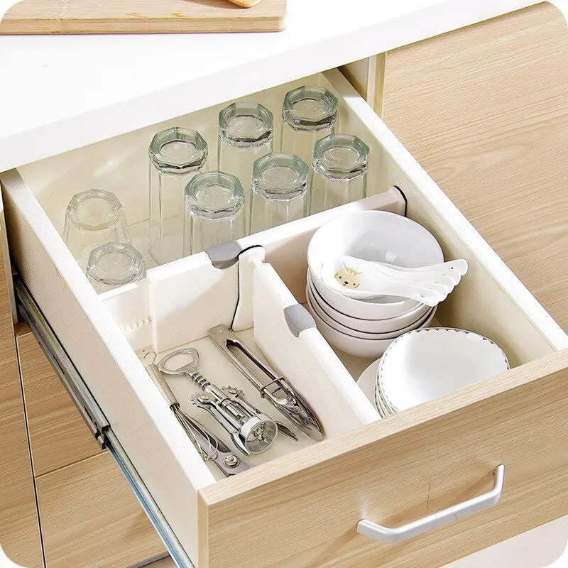 Adjustable expandable drawer dividers separating items in a kitchen drawer