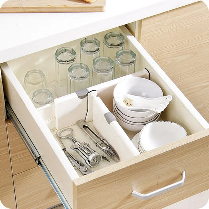 Adjustable expandable drawer dividers separating items in a kitchen drawer