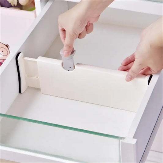Adjustable expandable drawer dividers separating items in a kitchen drawer